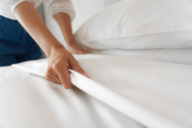 Baking soda being applied to a stained mattress to illustrate a DIY cleaning solution